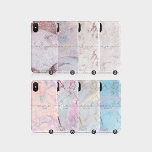 Könnte beinhalten: Acht verschiedene iPhone-Hüllen mit Marmormustern und darauf geschriebenen Namen. Die Hüllen sind in Rosa, Blau, Weiß und Grau.