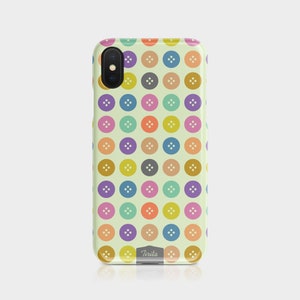 Puede incluir: Una funda de tel&eacute;fono colorida con un patr&oacute;n de botones en varios colores, incluyendo amarillo, naranja, rojo, verde, azul, morado y gris. La funda tiene un fondo blanco y la palabra "Tirita" est&aacute; impresa en la parte inferior.