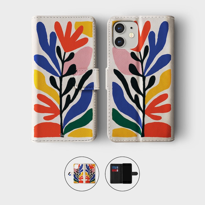 May include: White phone case with a colorful floral design. The design features red, blue, yellow, and pink shapes on a white background. The case has a magnetic closure and a cutout for the phone's camera.