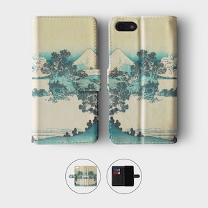 May include: A beige leather phone case with a Japanese-inspired design featuring a mountain and trees in blue and green hues. The case has a flap that folds over the phone screen and a slot for cards.
