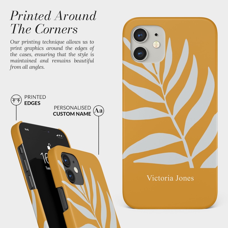 Pode incluir: Capa de telefone amarelo mostarda com um design de folha branca. O nome "Victoria Jones" est&aacute; impresso na parte inferior. O texto "Printed Around The Corners" &eacute; vis&iacute;vel no fundo.