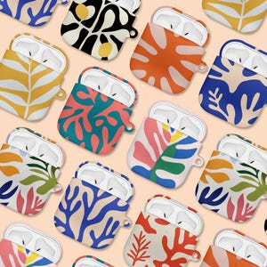 May include: Assortment of colorful AirPod cases with abstract floral patterns. The cases are made of silicone and have a variety of colors, including blue, green, red, orange, and yellow.