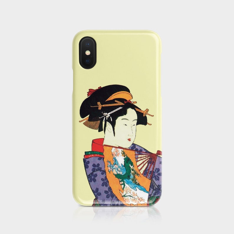 May include: A yellow phone case featuring a Japanese geisha illustration. The geisha is depicted in traditional attire with a fan, and the case has a glossy finish. The design includes shades of purple, orange, and green.