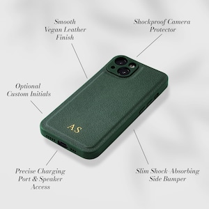 May include: A green phone case with a shockproof camera protector and a smooth vegan leather finish. The case has a slim shock-absorbing side bumper and precise charging port and speaker access. The case has the initials "AS" embossed on the back.