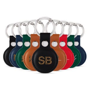 Peut inclure: Un ensemble de dix porte-clés en cuir de différentes couleurs et designs. Chaque porte-clés est doté d'une étiquette ronde en cuir avec un anneau métallique. Les étiquettes présentent divers motifs, notamment des initiales, un imprimé léopard et une signature manuscrite.