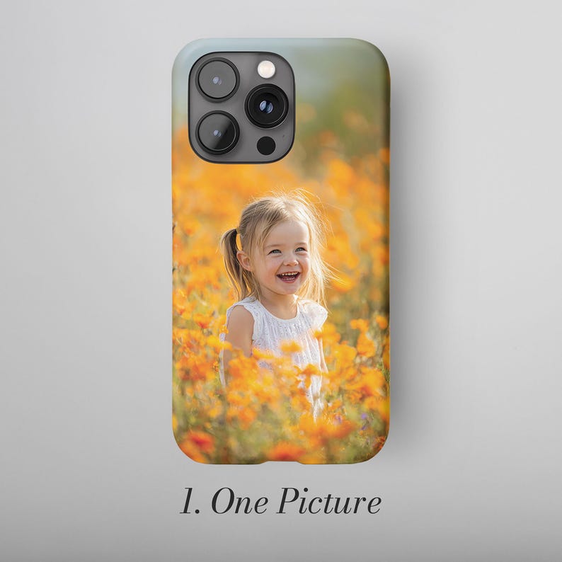 May include: A phone case featuring a photograph of a smiling child in a field of orange flowers. The case has a light blue top and the text "1. One Picture" at the bottom.