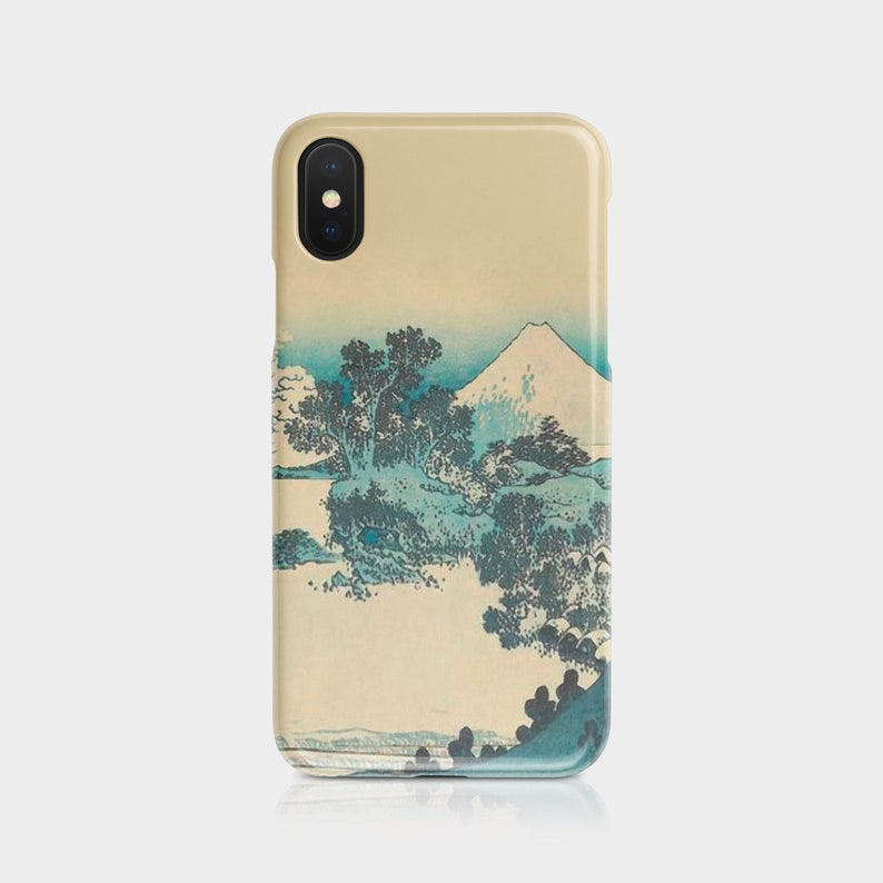 May include: A beige phone case featuring a Japanese landscape painting with a snow-capped mountain, trees, and water in shades of blue and green. The case has a glossy finish and a camera cutout.