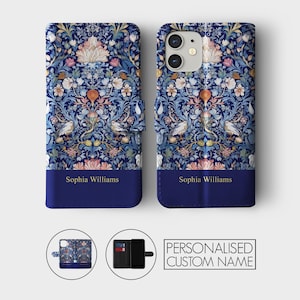 May include: A blue and floral patterned phone case with a flap that folds over the front of the phone. The case has a personalized name, "Sophia Williams", printed in gold lettering on the front flap. The case is shown closed and open, revealing a slot for cards and a pocket for cash.