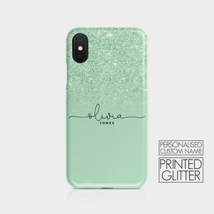 K&ouml;nnte beinhalten: Eine Handyh&uuml;lle aus gr&uuml;nem Glitzer mit einem personalisierten Namen, "Olivia Jones", in schwarzer Schrift. Die H&uuml;lle besteht aus bedrucktem Glitzer und hat einen Farbverlauf von Dunkelgr&uuml;n zu Hellgr&uuml;n.