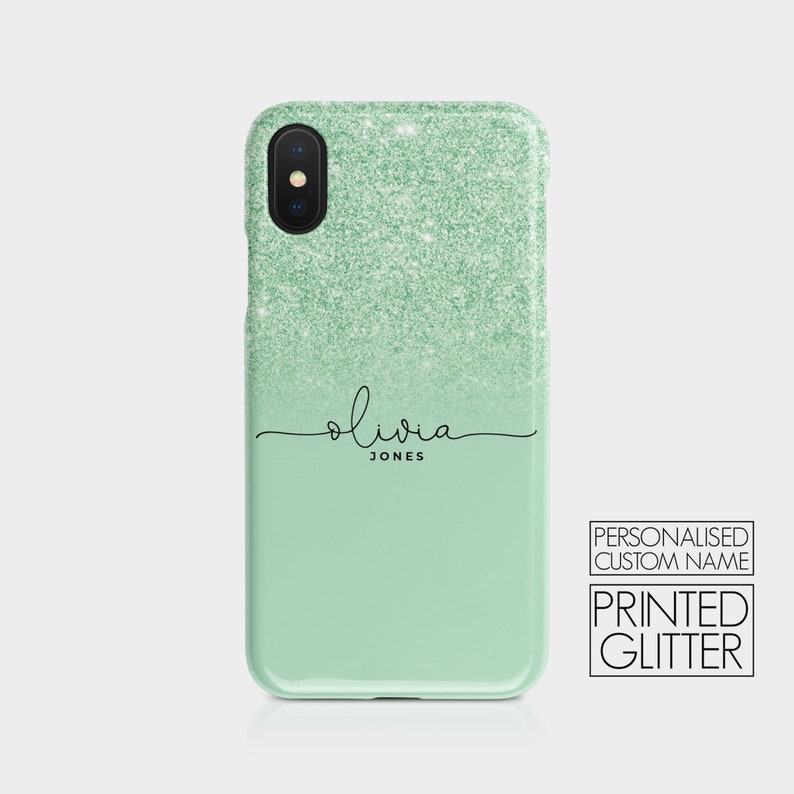 K&ouml;nnte beinhalten: Eine Handyh&uuml;lle aus gr&uuml;nem Glitzer mit einem personalisierten Namen, "Olivia Jones", in schwarzer Schrift. Die H&uuml;lle besteht aus bedrucktem Glitzer und hat einen Farbverlauf von Dunkelgr&uuml;n zu Hellgr&uuml;n.