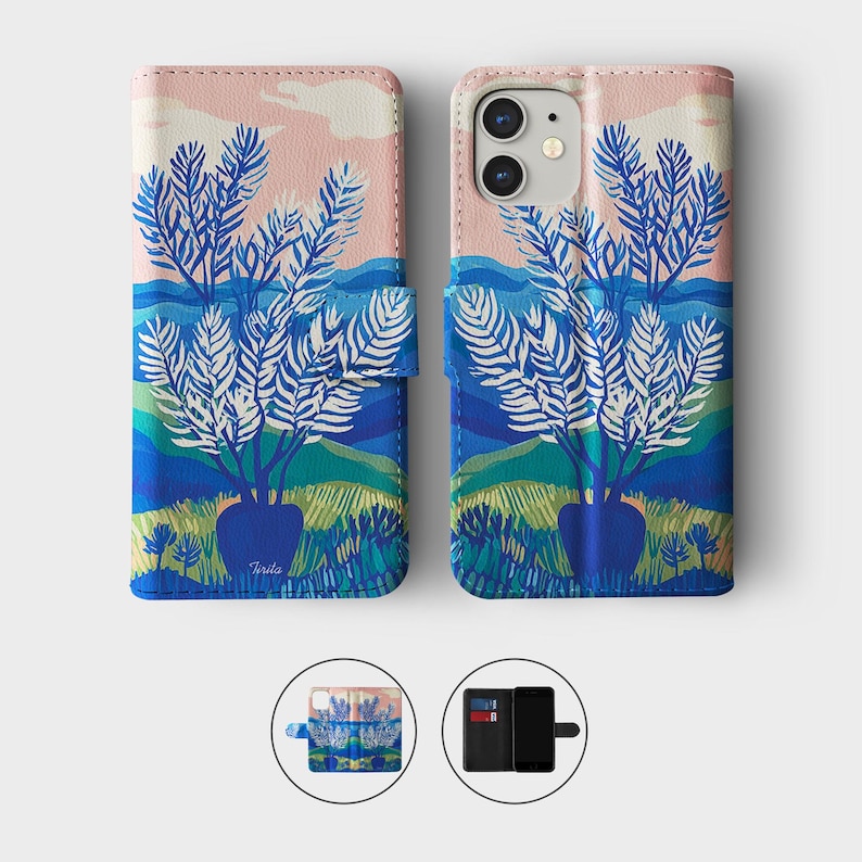 May include: A phone case with a landscape design. The case features a blue vase with white leafed branches, set against a backdrop of blue hills, green fields, and a pink and blue sky. The case is shown open and closed.
