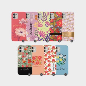 Pode incluir: Nove capas de telefone diferentes com padrões florais e nomes personalizados. As capas são de diferentes cores e apresentam uma variedade de designs florais.