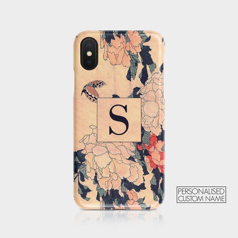 May include: A personalized phone case with a floral design featuring pink and red flowers, green leaves, and a butterfly. The case has a cream background and a black letter "S" in a square.