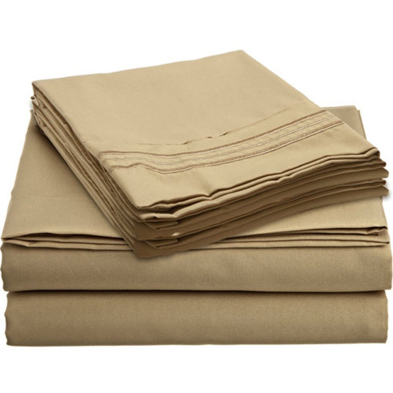 May include: A stack of beige bed sheets with a subtle striped pattern. The sheets are folded neatly and appear soft and comfortable.