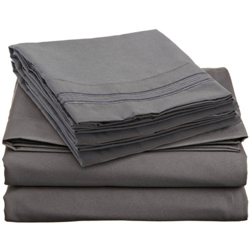 May include: A stack of gray bed sheets with a subtle stripe detail. The sheets are folded neatly and appear soft and comfortable.
