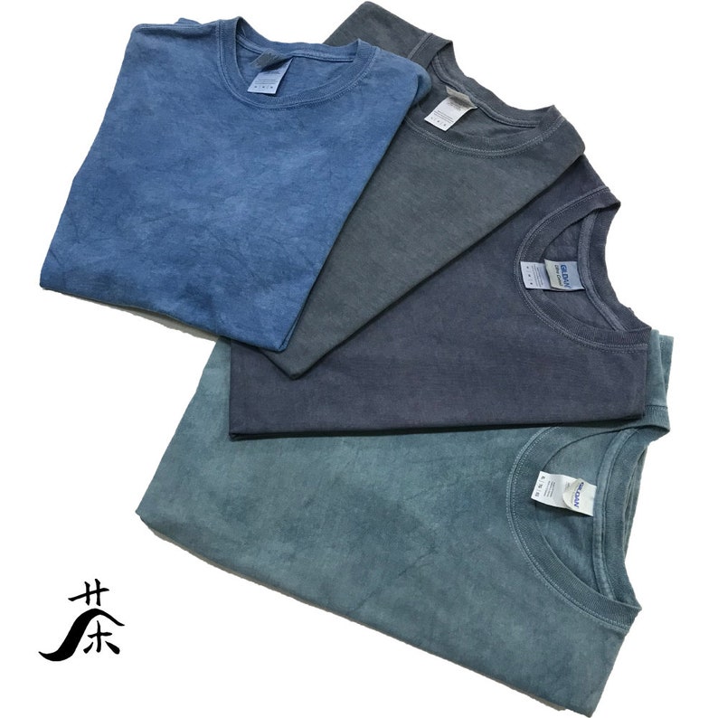 May include: Four folded t-shirts in different shades of blue. The shirts are made of a soft, comfortable fabric and have a relaxed fit.