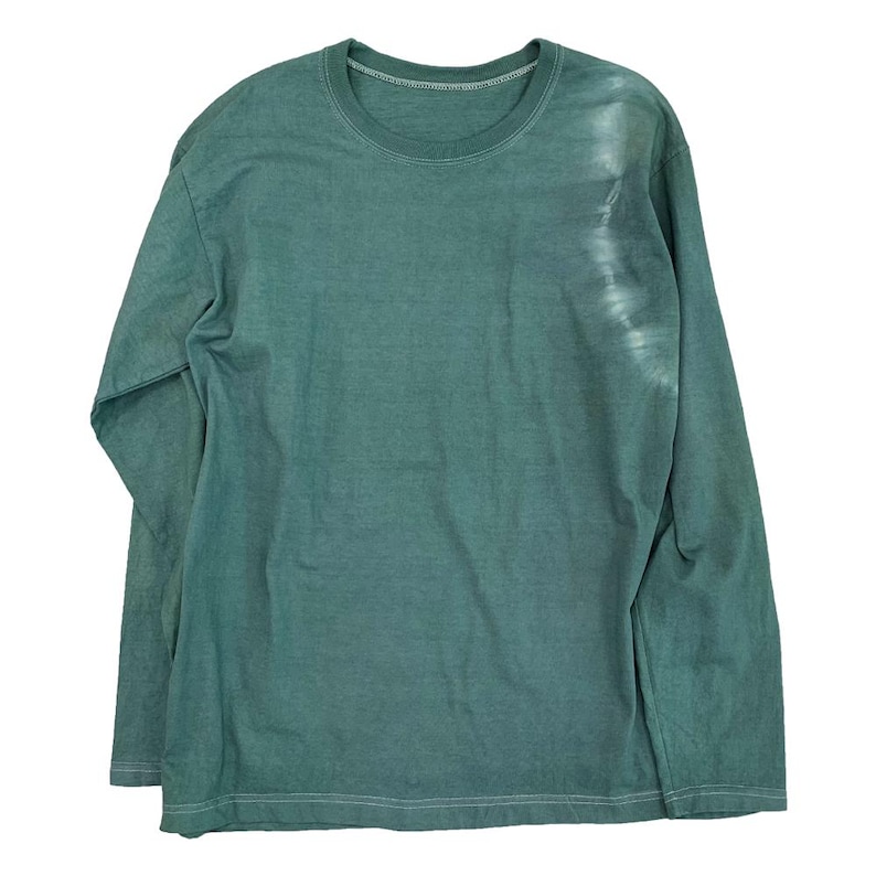 May include: A long-sleeved, crew neck shirt in a muted teal green color. The shirt has a slightly faded appearance, with a lighter, almost white, vertical streak on the right side. The fabric appears soft and comfortable.