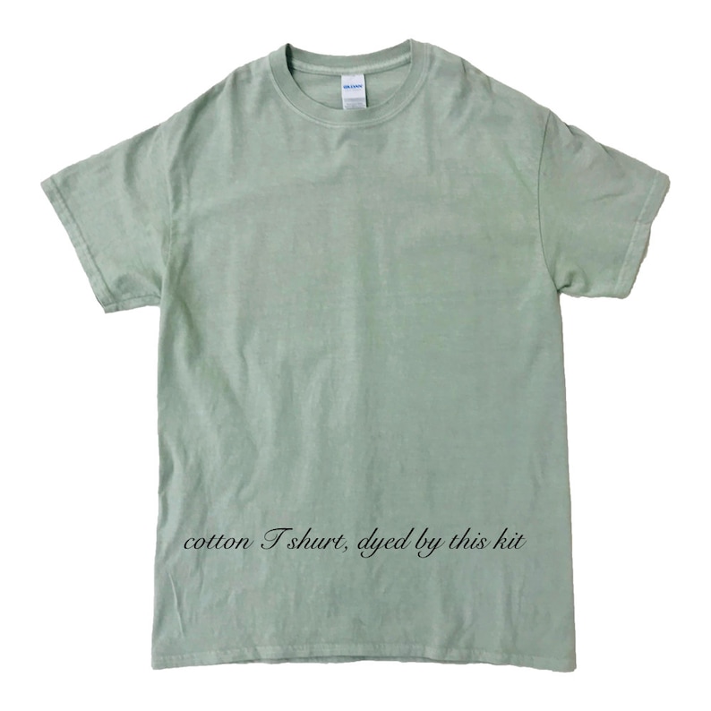 May include: A light green cotton T-shirt with short sleeves. The shirt has a crew neck and a relaxed fit. The text "cotton T shirt, dyed by this kit" is printed in black script at the bottom of the shirt.