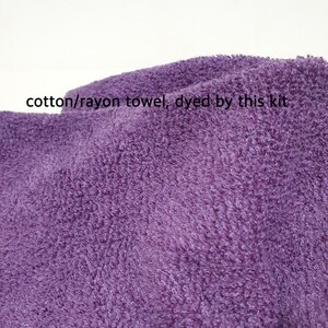 May include: Close-up of a textured, purple cotton/rayon towel. The towel has a soft, plush appearance. Text on the image reads: "cotton/rayon towel, dyed by this kit."