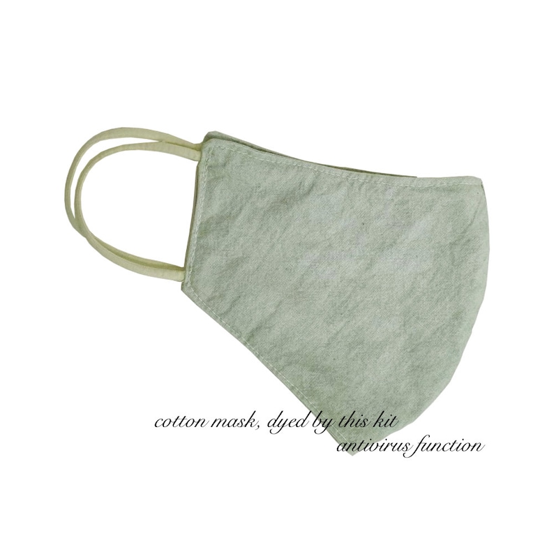 May include: A light green cotton face mask with cream-colored ear loops. The mask has a textured appearance and is designed to cover the nose and mouth. Text on the image reads "cotton mask, dyed by this kit antivirus function."