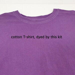 May include: A close-up of a purple cotton T-shirt. The shirt has a crew neck with white stitching. The text "cotton T-shirt, dyed by this kit" is printed on the shirt.