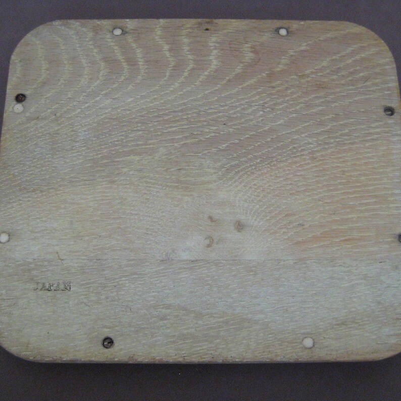 May include: A light-coloured, rectangular wooden tray with rounded corners. The wood grain is visible, and the tray has several small screw heads and the word "JAPAN" stamped on it.