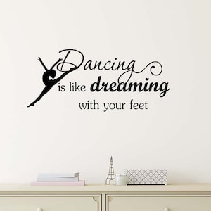 May include: Black and white wall decal with a silhouette of a dancer and the text "Dancing is like dreaming with your feet".