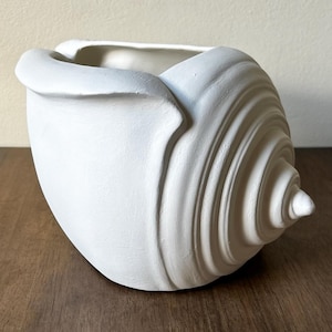 May include: A handmade wooden sign with the text "Welcome" in a playful font. The sign is painted white with a distressed finish, and features a small, decorative floral element. The sign measures approximately 12 inches wide.