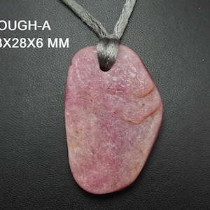 May include: A pink pendant with a grey cord. The pendant is a rough, irregular shape, measuring approximately 4.3 x 2.8 x 0.6 cm. The text "ROUGH-A 43X28X6 MM" is visible in the upper left corner.