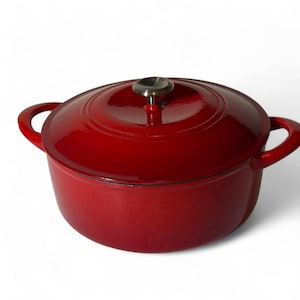 May include: A round, deep red enameled cast iron Dutch oven with a matching lid. The pot features two side handles and a central metallic knob on the lid. The exterior has a glossy, smooth finish, and the design is circular with a wide base.