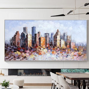 May include: A colorful abstract painting of a cityscape with tall buildings in various shades of brown, gray, and blue. The buildings are set against a light blue sky with white clouds. The painting is done in a loose, impressionistic style with visible brushstrokes.