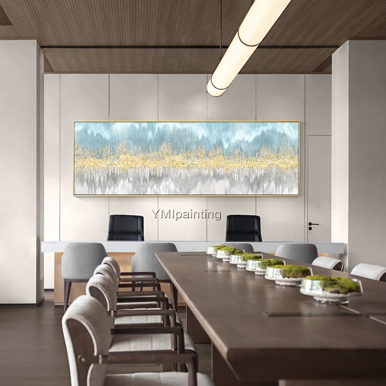 May include: Abstract painting with blue, white, and gold hues. The painting is hanging on a wall in a modern office setting with a long wooden table and chairs.