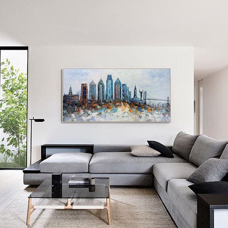 Pode incluir: Uma pintura de um horizonte urbano com edif&iacute;cios altos em tons de azul, marrom e branco. A pintura &eacute; emoldurada e pendurada em uma parede branca em uma sala de estar.