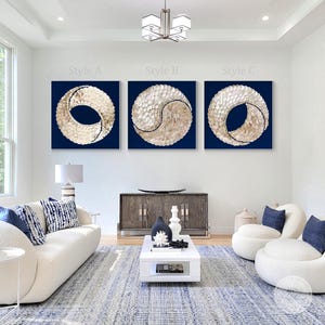 Peut inclure: Trois œuvres d'art murales abstraites avec un fond bleu et un motif blanc et or. Le motif est un cercle avec un cercle plus petit à l'intérieur, créant un symbole yin yang. Les pièces sont étiquetées "Style A", "Style B" et "Style C".