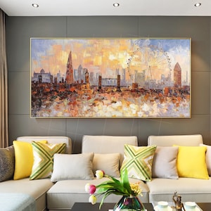May include: A painting of a cityscape with a Ferris wheel in the foreground. The cityscape is painted in a colorful, impressionistic style with a focus on the buildings and the Ferris wheel. The painting is framed in a gold frame.