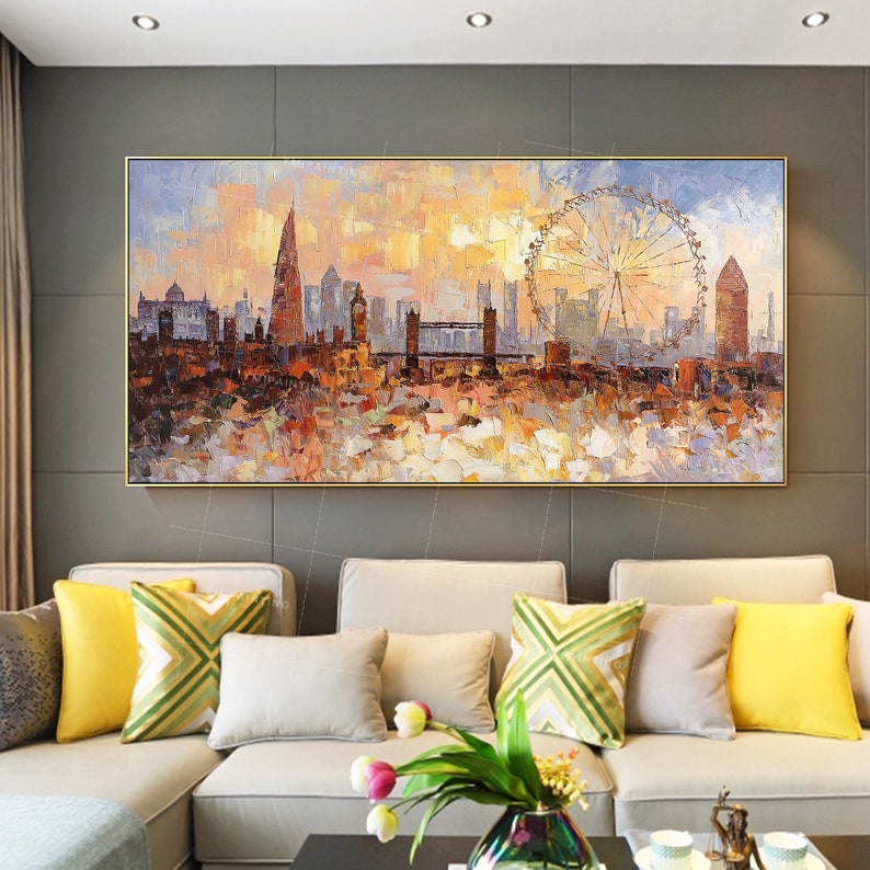 May include: A painting of a cityscape with a Ferris wheel in the foreground. The cityscape is painted in a colorful, impressionistic style with a focus on the buildings and the Ferris wheel. The painting is framed in a gold frame.