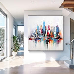以下が含まれることがあります： カラフルなスカイラインを持つ、大きな抽象的な都市景観の絵画。このアートワークは、青、赤、オレンジ、黄色の色合いの活気ある建物の配列を特徴とし、下部に反射する水の効果があります。