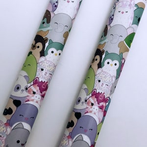 Puede incluir: Dos tubos cubiertos de tela colorida con una variedad de caras de animales de dibujos animados. Los tubos están cubiertos con tela amarilla y azul con lunares.