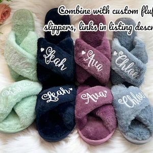 May include: Four pairs of fluffy open-toe slippers in mint green, navy blue, plum, and grey. Each pair features a crisscross strap design with white embroidered names: Kyla, Leah, Ava, and Chloe. Text reads: Combine with custom fluffy slippers, links in listing description.