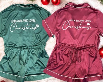 May include: Two sets of Christmas pajamas in emerald green and burgundy. Each set includes a short-sleeved top and shorts with a drawstring waist. The text "JUST A GIRL WHO LOVES Christmas" is printed on the back of each top.