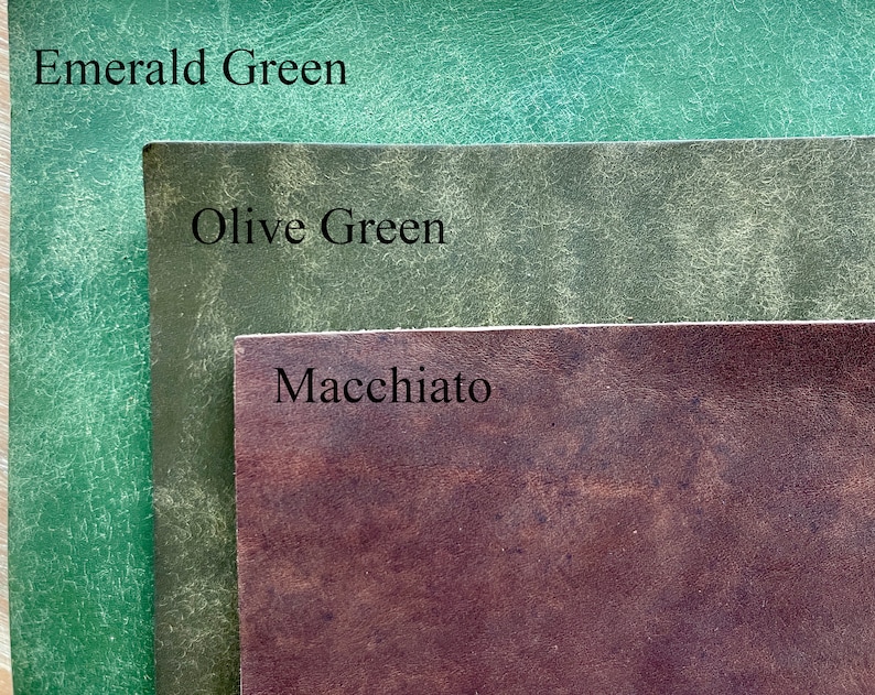 May include: Close-up of three leather swatches in shades of green and brown. The top swatch is Emerald Green, the middle is Olive Green, and the bottom is Macchiato. The names of the colors are printed on the swatches.