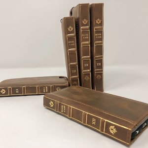 May include: Five brown leather phone cases designed to look like old books. Each case has gold lettering that reads "Book Case" and "XII".