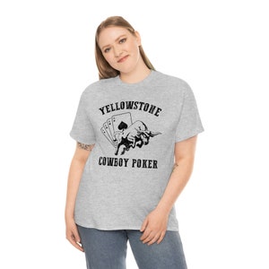 Könnte beinhalten: Ein graues T-Shirt mit einer schwarzen Grafik eines Bullen und Spielkarten. Der Text "Yellowstone Cowboy Poker" ist auf dem Shirt aufgedruckt.