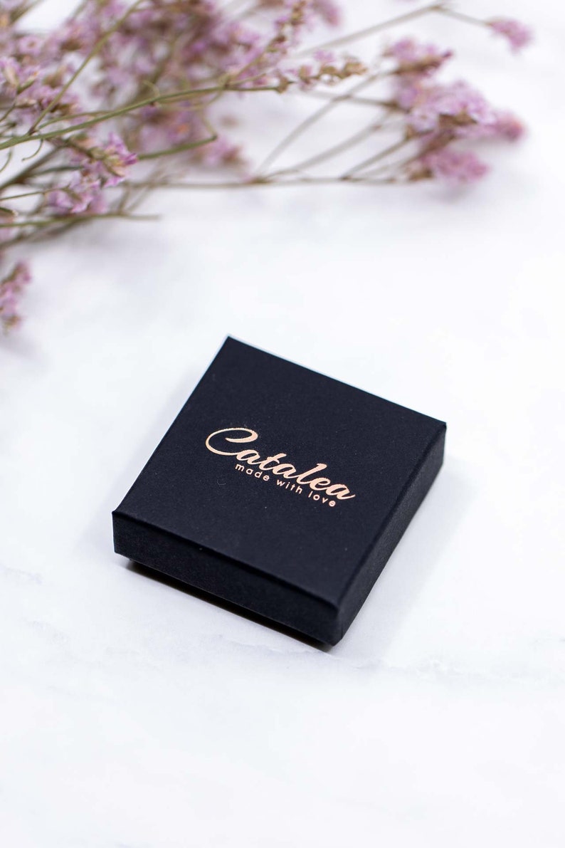 May include: A black square box with the text "Catalea made with love" in gold lettering.