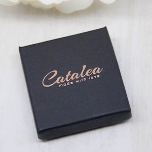 May include: A black box with the text "Catalea made with love" in rose gold lettering.
