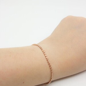 May include: A delicate rose gold bracelet with a chain of small, round beads.