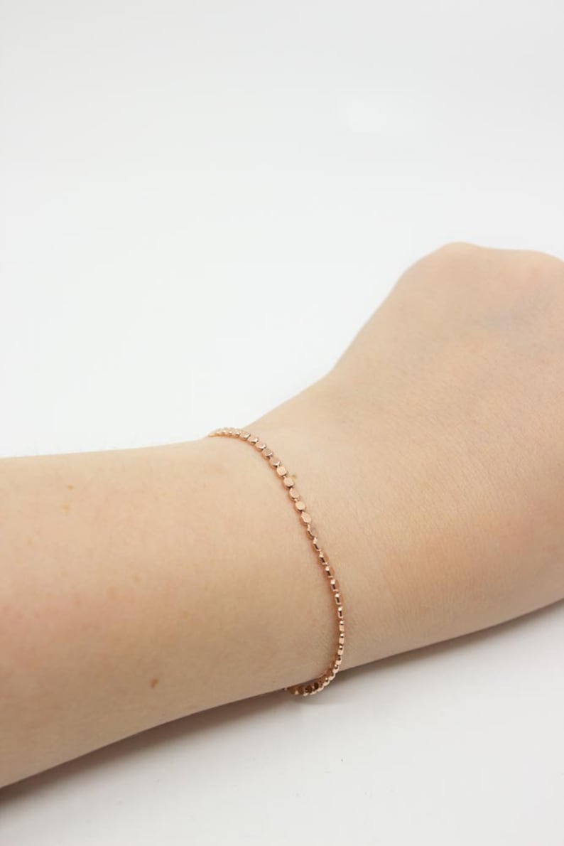 May include: A delicate rose gold bracelet with a chain of small, round beads.