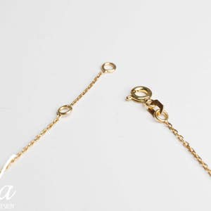 May include: A gold chain necklace with a lobster clasp closure. The chain is delicate and features a simple design.