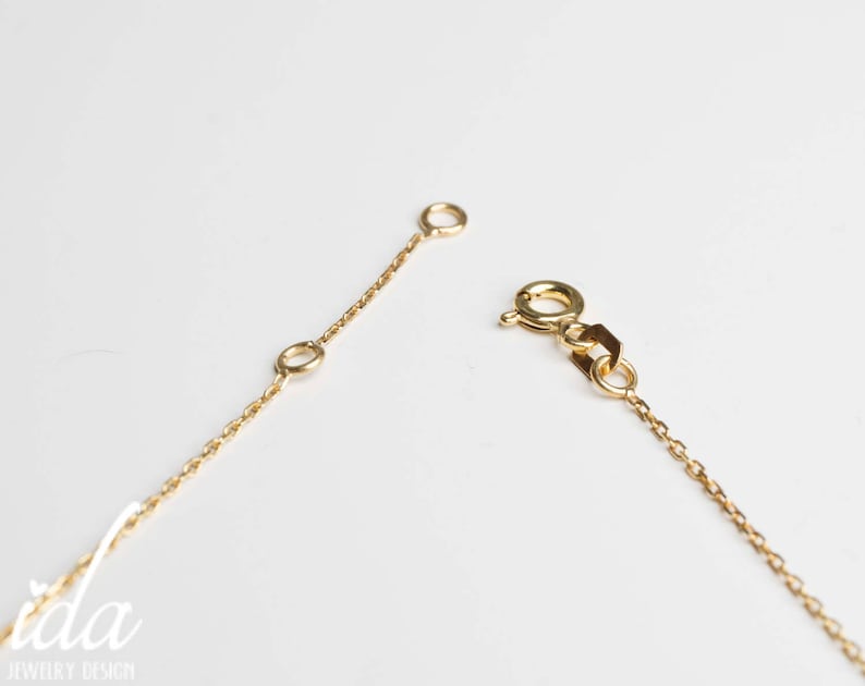 May include: A gold chain necklace with a lobster clasp closure. The chain is delicate and features a simple design.
