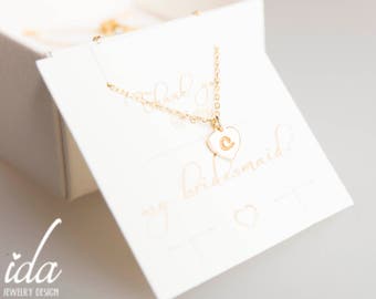 Peut inclure: Un collier en or avec un petit pendentif en forme de cœur blanc orné de la lettre "C". Le collier est présenté dans une boîte blanche avec une carte qui dit "Merci d'être ma demoiselle d'honneur".